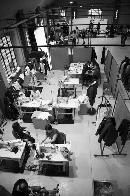Black and white interior of a modern office with employees working at desks.
