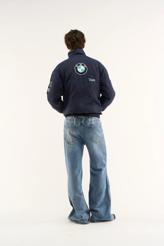 Person wearing a BMW Petronas Racing Jacket Premium Printed Designwith a BMW logo on the back, standing against a white background