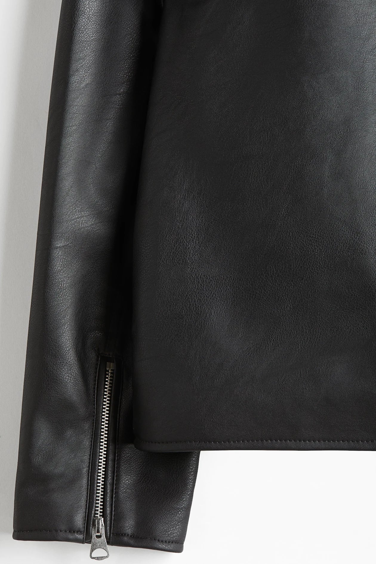 Full body lifestyle shot of the model wearing the black oversized boxy leather jacket layered over streetwear bottoms. Perfectly demonstrates the highly sought-after Opium darkwear proportions combining the wide minimalist moto jacket with baggy cargo pants.