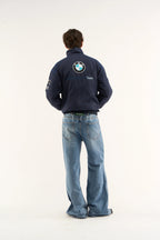 Person wearing a BMW Petronas Racing Jacket Premium Printed Designwith a BMW logo on the back, standing against a white background