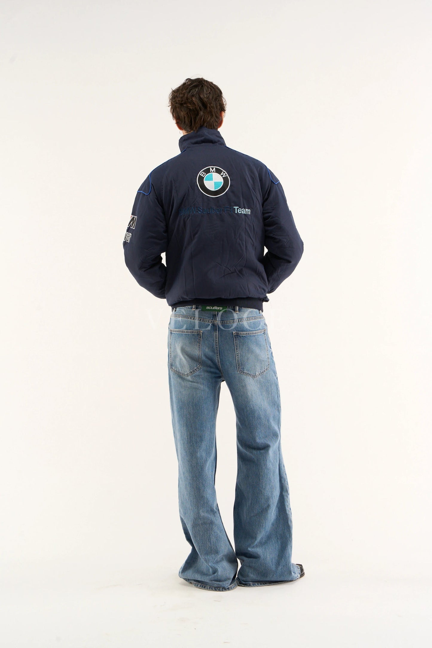 Person wearing a BMW Petronas Racing Jacket Premium Printed Designwith a BMW logo on the back, standing against a white background