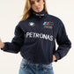 Model posing in BMW Petronas parachute jacket with hands in pockets