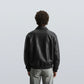 Back view of black bomber leather jacket unisex with ribbed hem and smooth leather texture, perfect for winter wear