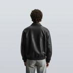 Back view of black bomber leather jacket unisex with ribbed hem and smooth leather texture, perfect for winter wear