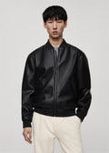 Model wearing a Premium black leather bomber jacket with classic bomber style fit on a plain background