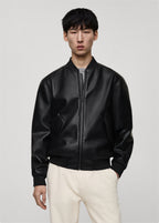 Model wearing a Premium black leather bomber jacket with classic bomber style fit on a plain background