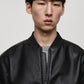 Close-up front view of Gigavibe Black Leather Bomber Jacket zipper and collar