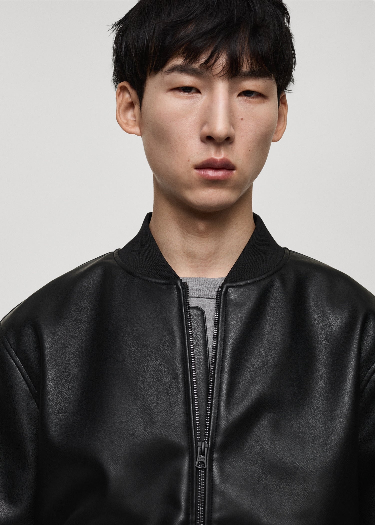Close-up front view of Gigavibe Black Leather Bomber Jacket zipper and collar
