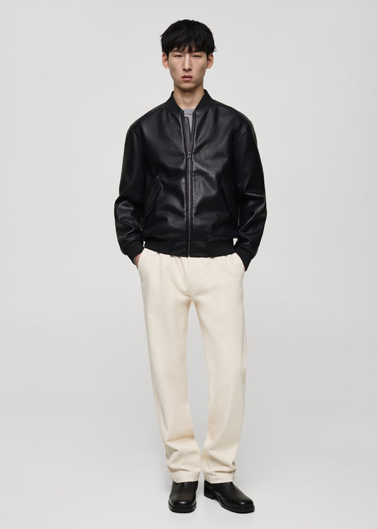 Front full-body shot of Gigavibe Black Leather Bomber Jacket styled with white pants