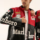 Detailed sleeve view of black Marlboro racing jacket with retro motorsport patches and leather craftsmanship