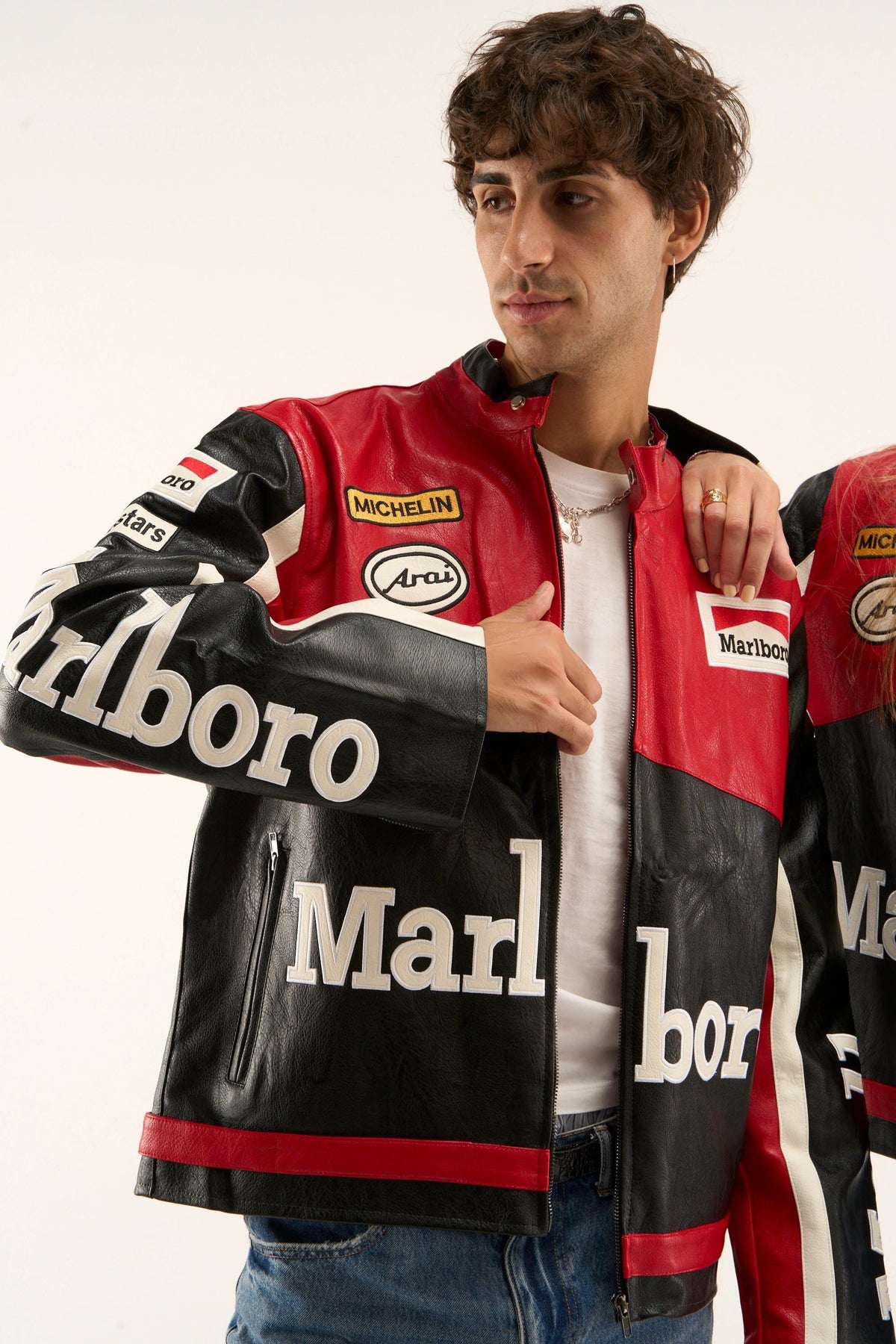 Detailed sleeve view of black Marlboro racing jacket with retro motorsport patches and leather craftsmanship