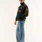 Model wearing Lamborghini embroidered jacket streetwear style and blue jeans on a white background