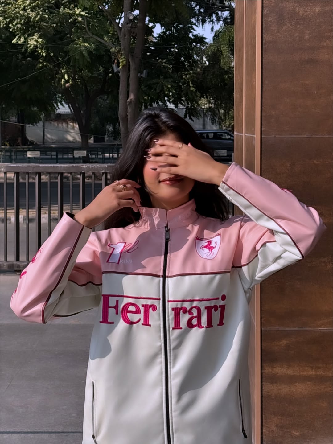 Model wearing pink Ferrari luxury racing jacket outdoors