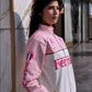 Woman wearing a pink and white jacket Rear view of pink Ferrari racing jacket with logo design