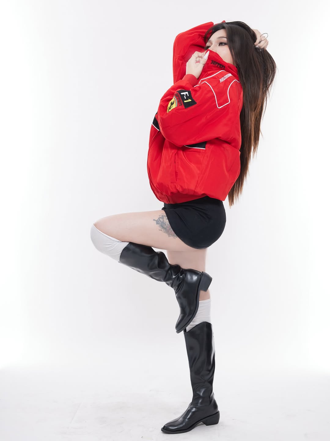 Model wearing red Ferrari jacket embroidered by Gigavibe, motorsport-inspired streetwear with Ferrari logo patches.