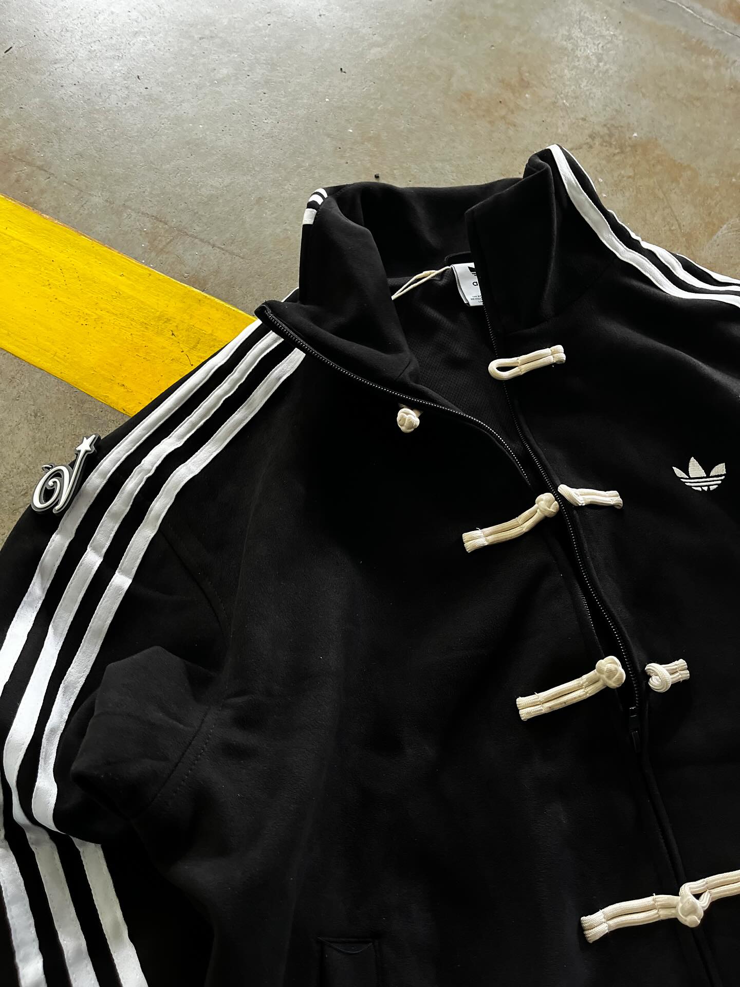 Close up detail of traditional knot buttons on the Gigavibe Black CNY Jacket