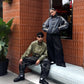 Side angle of the streetwear couple wearing the heavy earth-tone suede bombers. The extreme dropped shoulder profile expertly highlights the oversized genderless boxy fit meant for modern fashion.