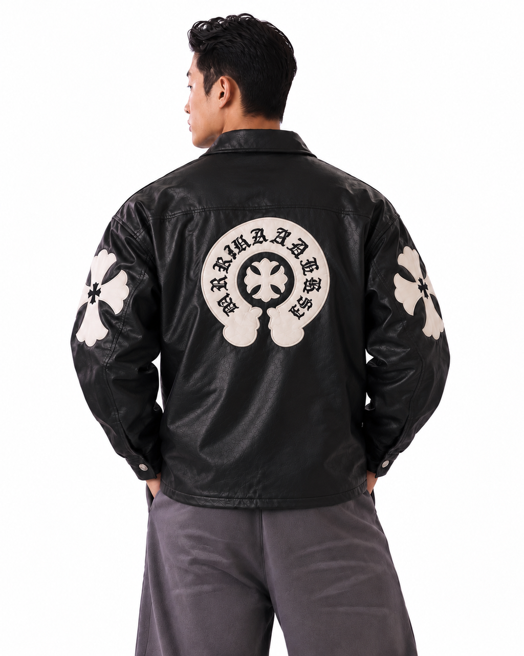 Back angle of male model wearing the black Gothic leather jacket, displaying the tonal black stitched cross patches across the back and sleeves