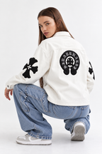 Rear view of female model displaying the stitched black leather cross patches and large Gothic back emblem on the cream leather body