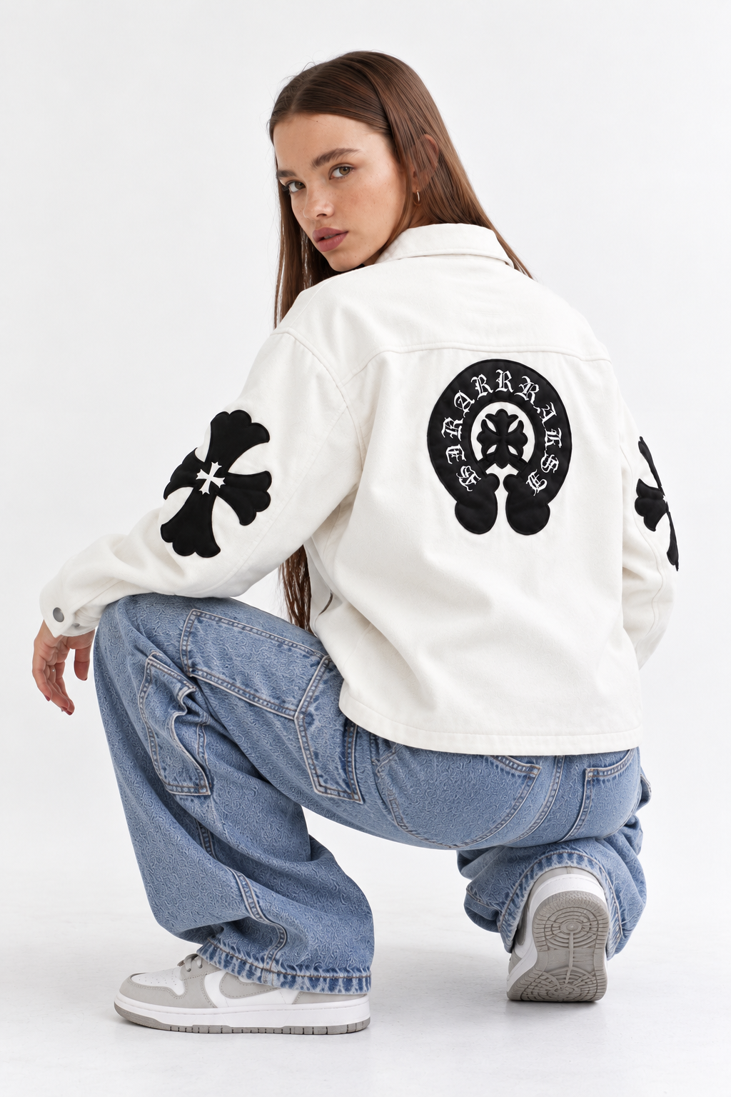 Rear view of female model displaying the stitched black leather cross patches and large Gothic back emblem on the cream leather body