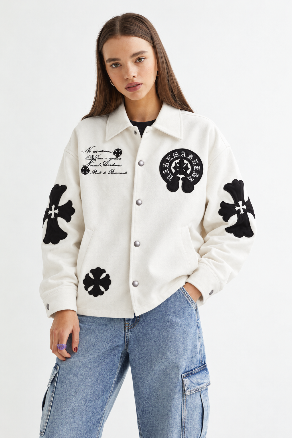 Female model wearing the unisex Alabaster White Gothic cross patch faux leather jacket, showcasing the modern boxy streetwear drape
