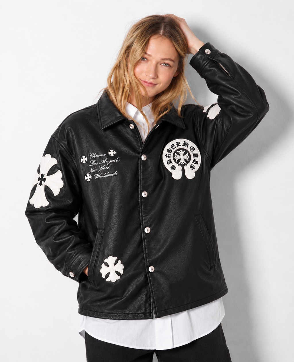 Front view of a Girl styling the black cross patch trucker jacket, showing the deep side welt pockets and silver snap fasteners