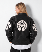 Back perspective of a female model wearing the black Gothic cross leather jacket, highlighting the rear horseshoe crest and arm patch detailing