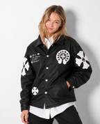 Female model wearing the unisex black Gothic cross patch leather jacket from the front, showing the clean drop-shoulder cut