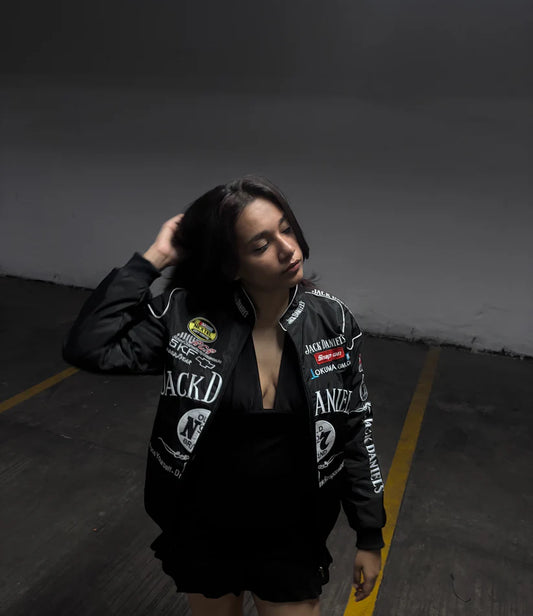 Model wearing Jack Daniels embroidered jacket unisex by Gigavibe in a parking lot, showcasing vintage racing style.