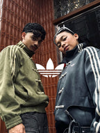 Male and female models posing in matching oversized vegan suede knot jackets in Olive and Grey. Showcasing the flawless unisex aesthetic and high-end matching streetwear couples outfit at Gigavibe.