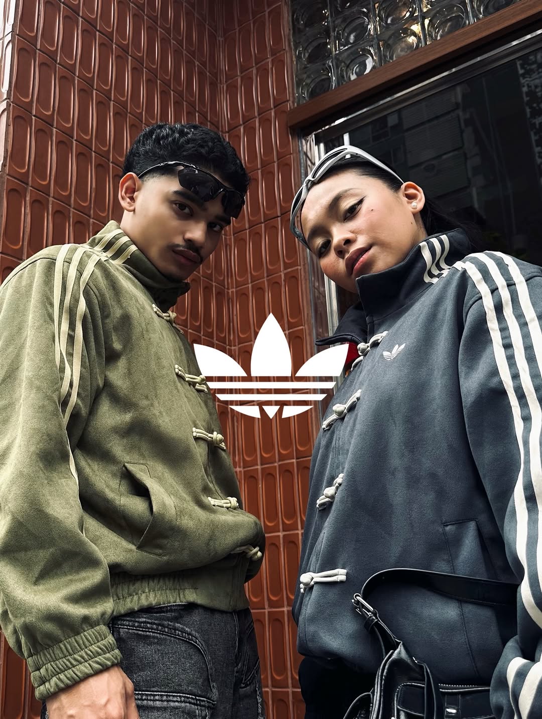 Male and female models posing in matching oversized vegan suede knot jackets in Olive and Grey. Showcasing the flawless unisex aesthetic and high-end matching streetwear couples outfit at Gigavibe.