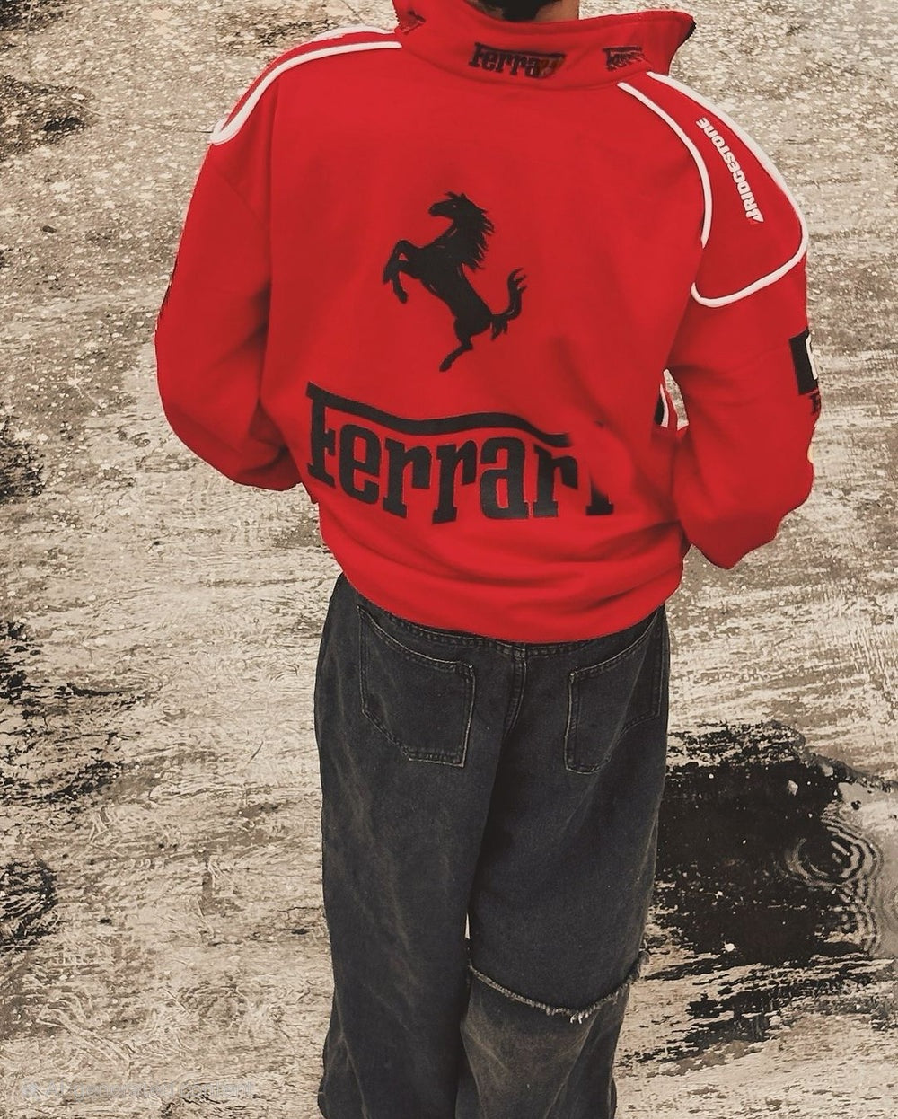 Back perspective of a male model wearing the red Ferrari parachute jacket, highlighting the bold printed racing typography