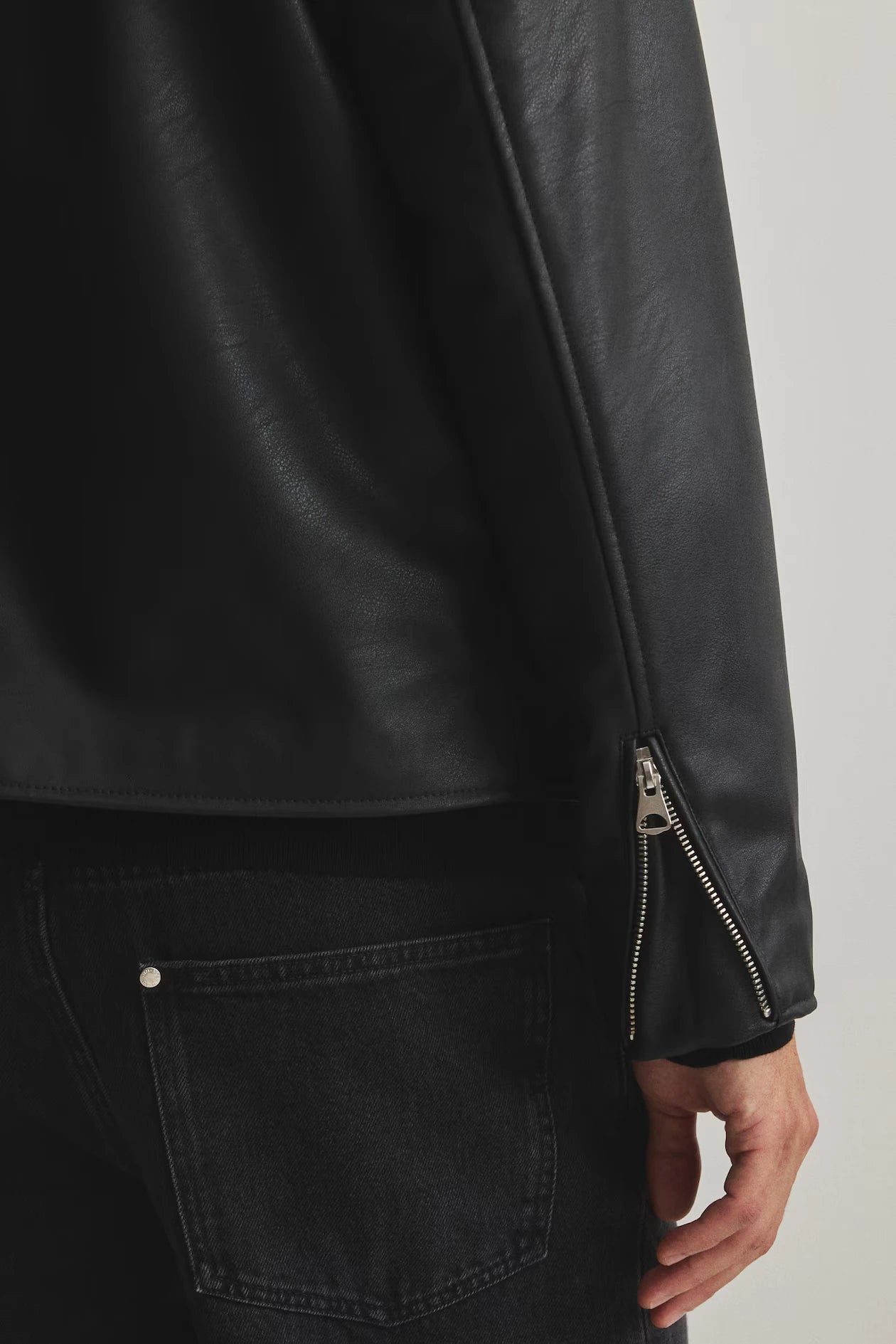 Macro close-up shot of the premium high-quality heavyweight faux leather matrix. Shows the highly detailed semi-matte grain finish completely devoid of cheap plastic shine, contrasted sharply by the stealthy metallic front zipper hardware.