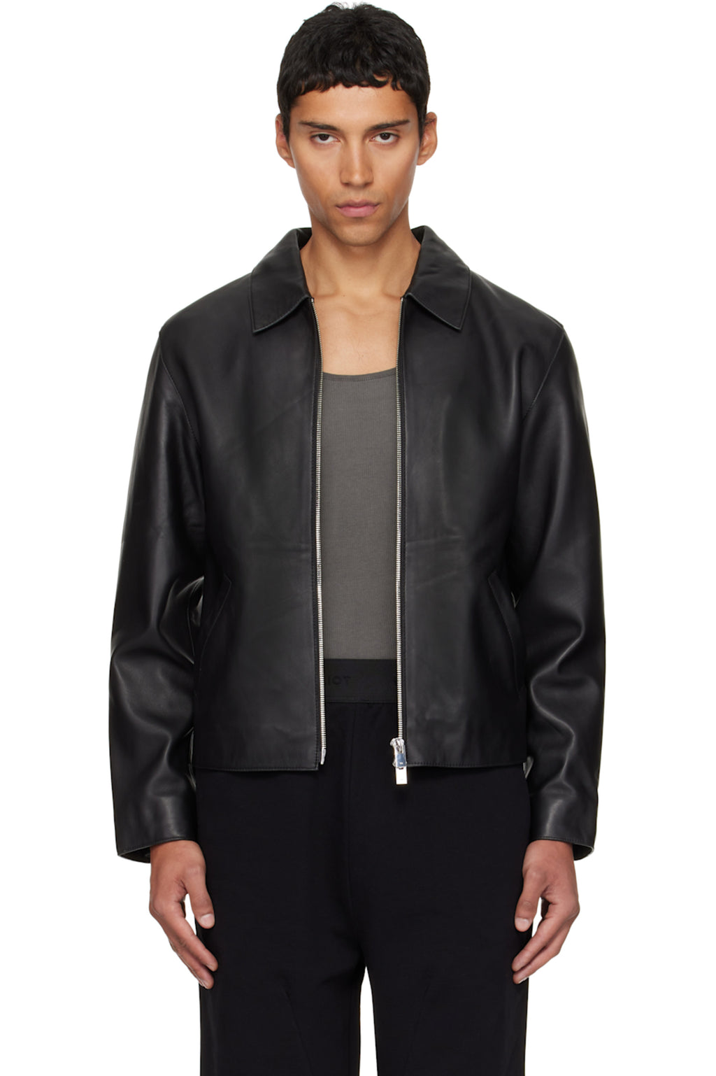 Direct front view of the Unisex Cropped Leather Jacket in matte black at Gigavibe. The model demonstrates the premium vegan leather drape, showing the exposed silver front zipper and the classic boxy proportions essential for modern darkwear fashion in India.
