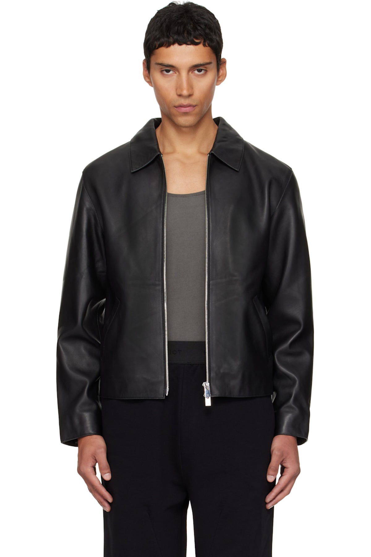 Direct front view of the Unisex Cropped Leather Jacket in matte black at Gigavibe. The model demonstrates the premium vegan leather drape, showing the exposed silver front zipper and the classic boxy proportions essential for modern darkwear fashion in India.