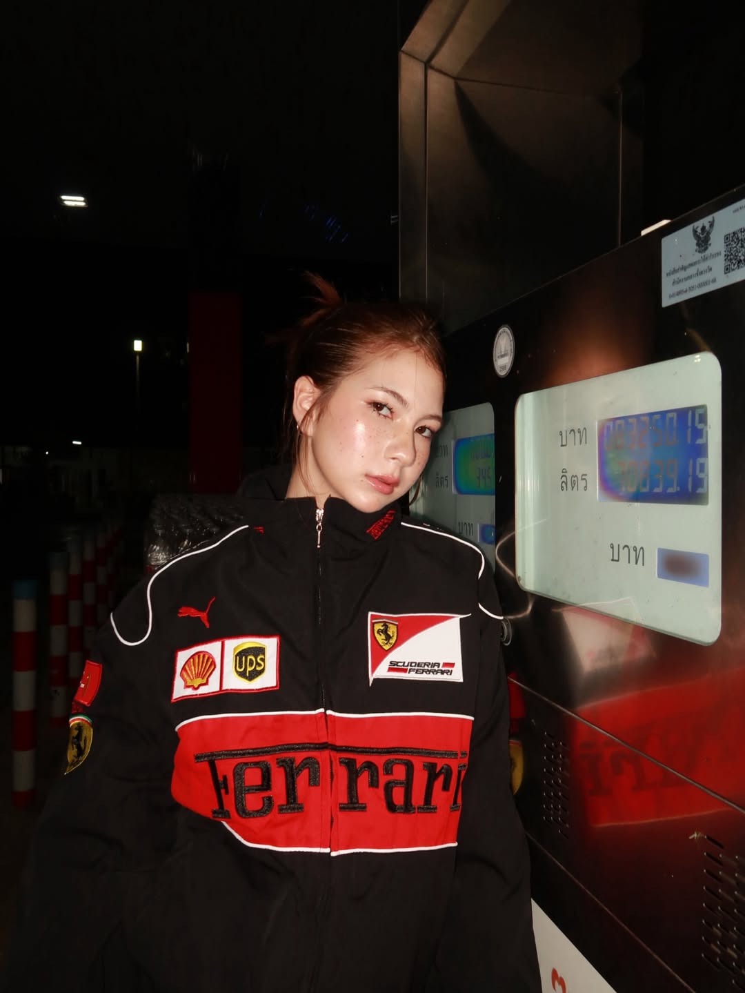 Close up of female model displaying the heavy-duty front metal zipper and ribbed knit collar on the black Ferrari embroidered jacket