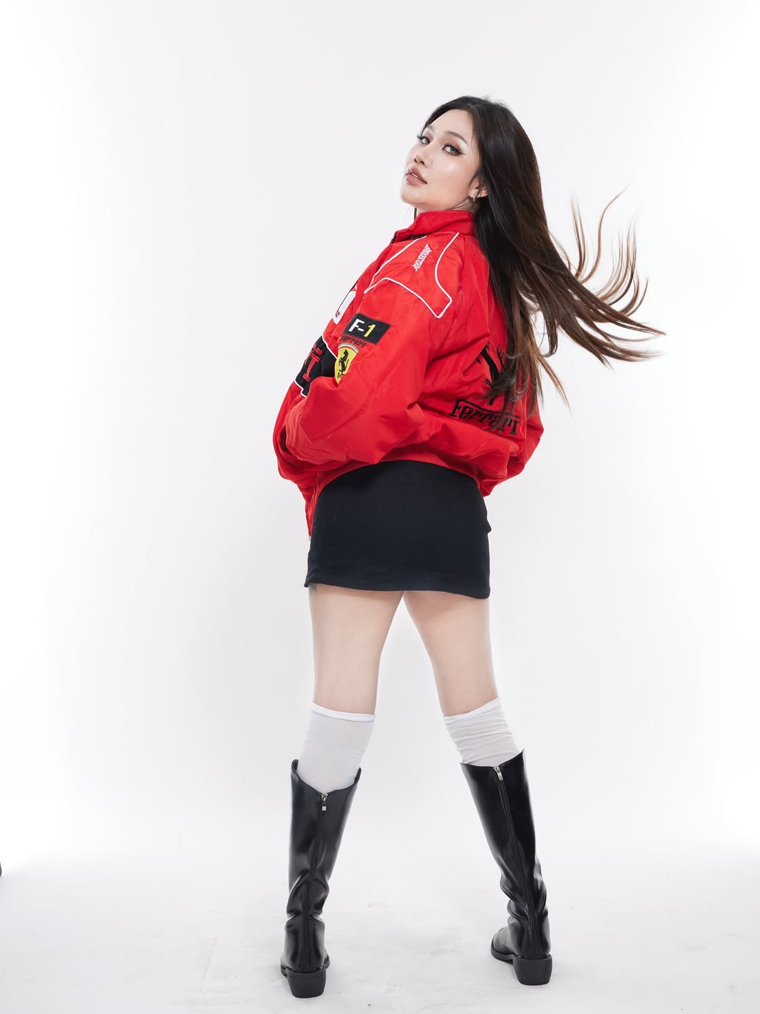 Outdoor candid shot of a girl in the oversized red Ferrari embroidered bomber jacket paired with black cargo pants and