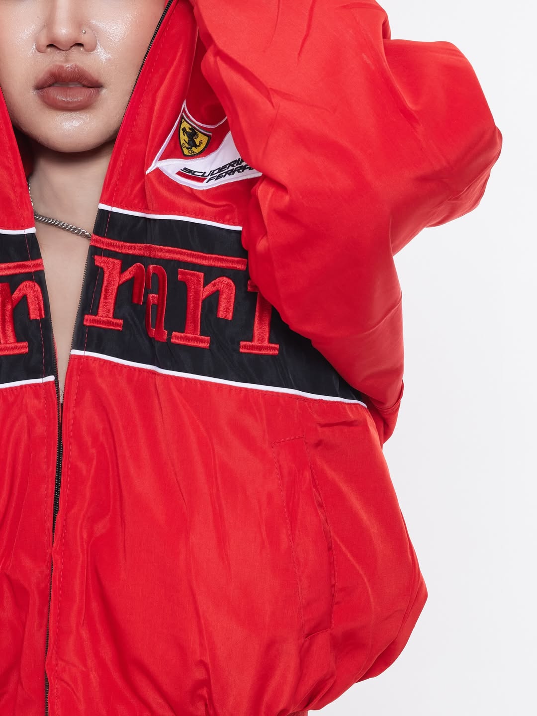 Close up of female model showing the heavy-duty front metal zipper and ribbed bomber collar on the red Ferrari racing jacket