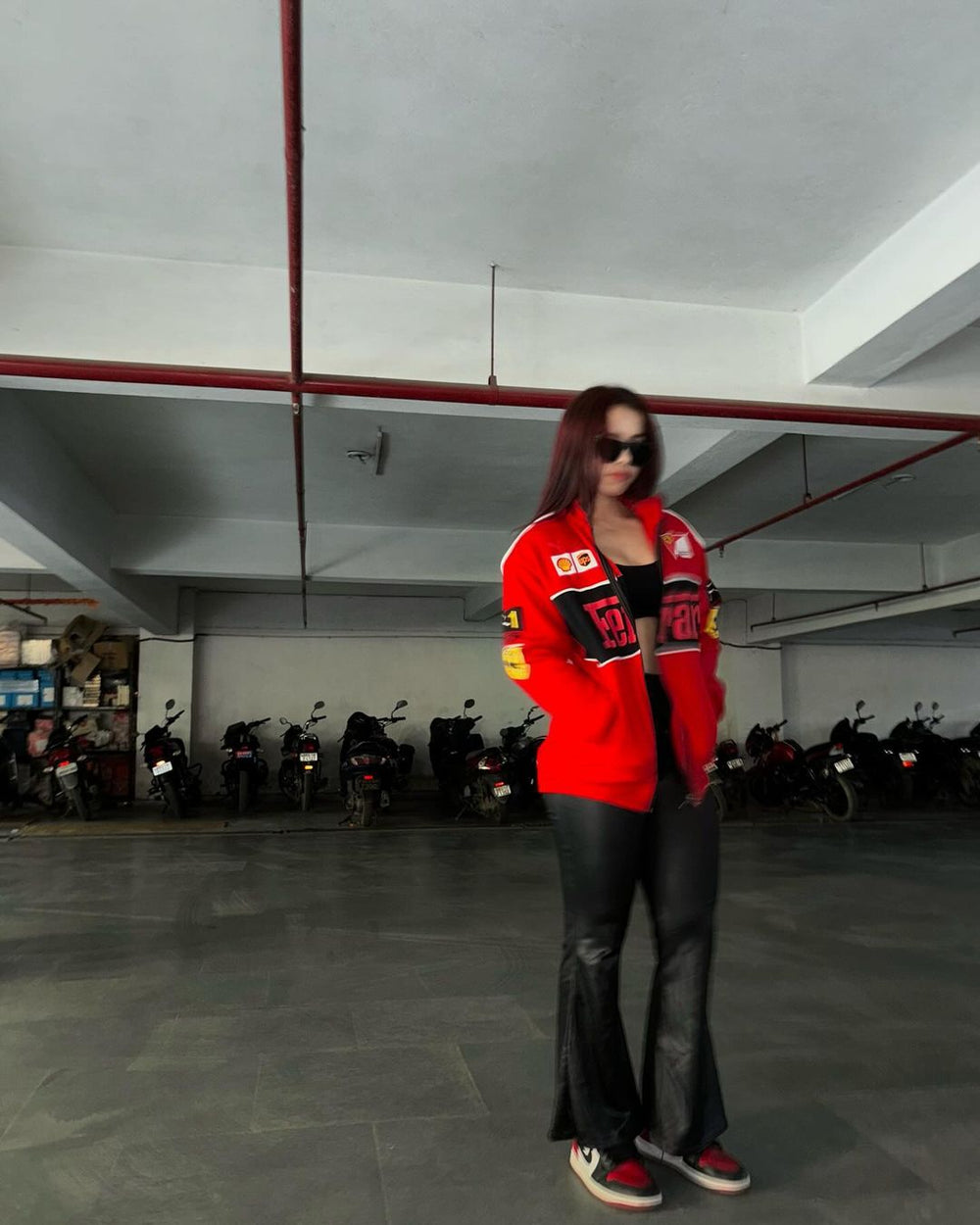 Side profile of a female model showing the crisp printed motorsport sponsor logos along the lightweight red parachute sleeve