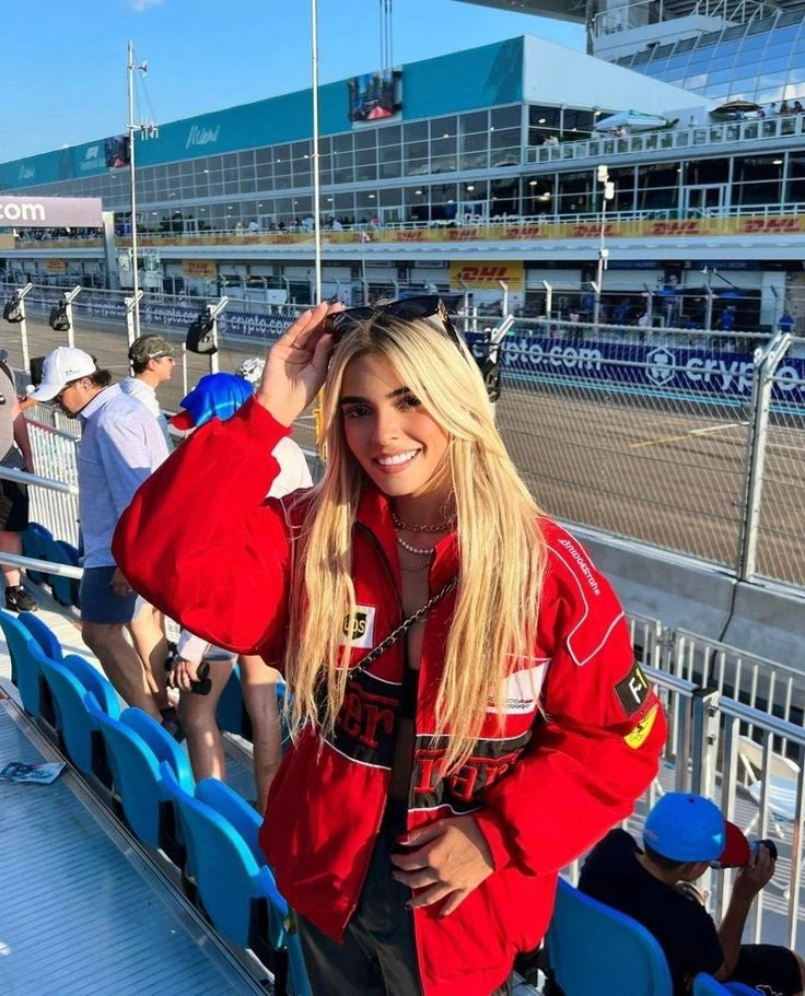 Female model wearing the red vintage Ferrari parachute racing jacket from the front, showcasing the lightweight windbreaker drape and printed graphics