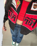 lose-up of the Y2K streetwear Ferrari F1 jacket in black, worn open over a red crop top. Features the breathable micro-mesh red lining and striking high-density chest graphics for aesthetic motorsport clothing India.